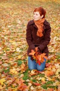 Woman Sitting in Fall Leaves